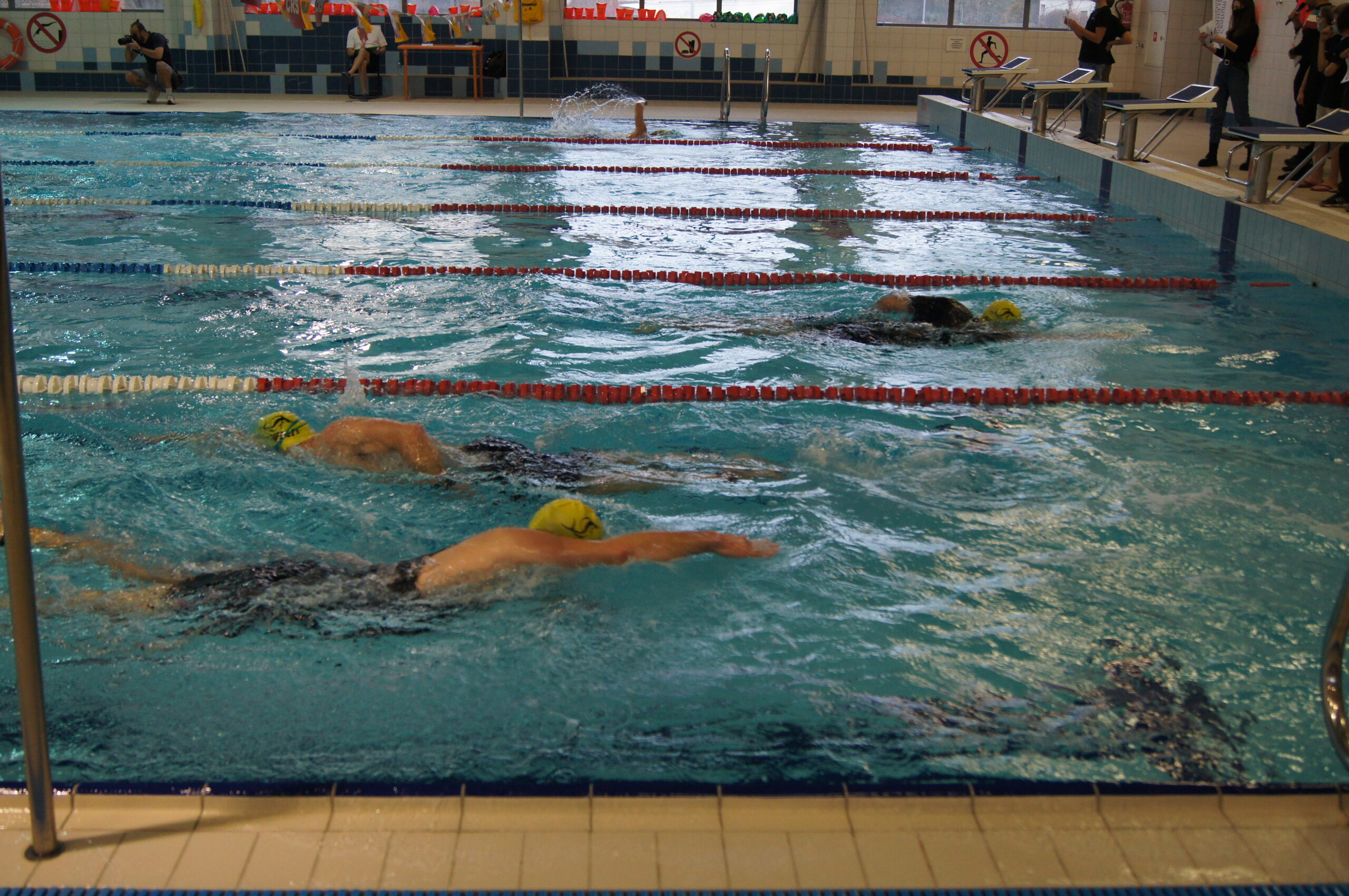 zawody triathlonowe pływalnia, pływający zawodnicy 