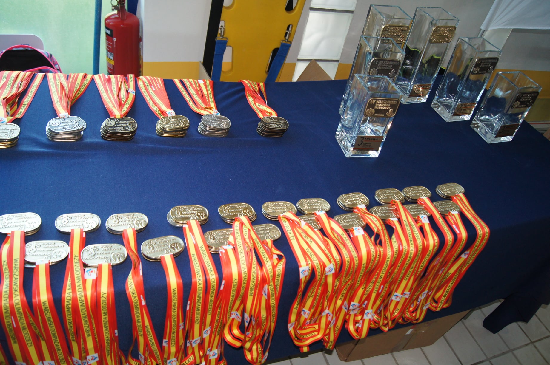 Stół z granatowym obrusem i medalami